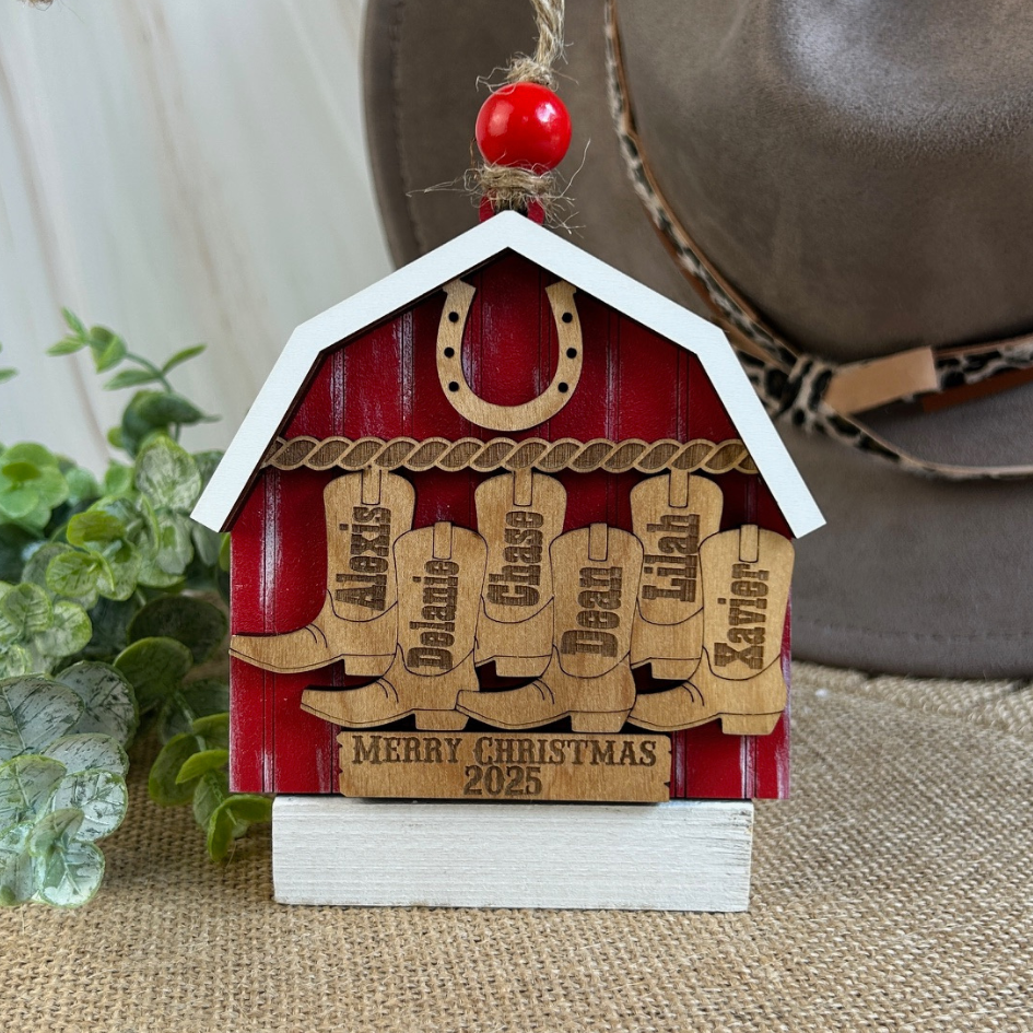 Red and white wooden ornament with engraved names and 'Merry Christmas 2025' text, hanging on a string.