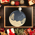 Baby's first Christmas ornament. A snowy scene with a baby foot outlined with stars in the sky.