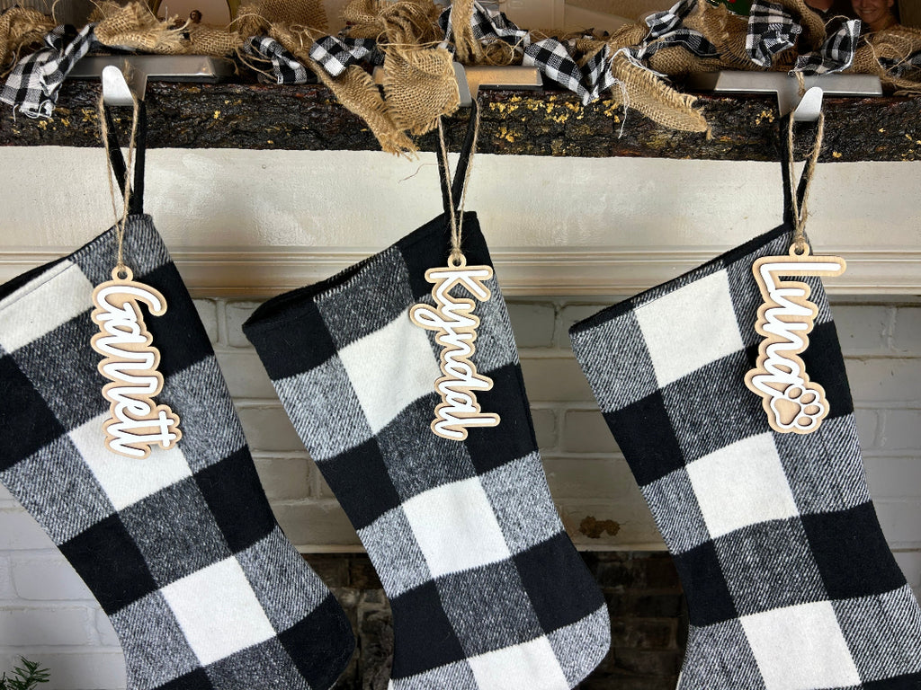 Name tags hanging with a stocking on a fireplace.