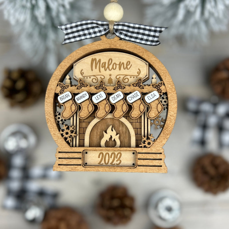 Snow globe version of the fireplace ornament with names on stockings